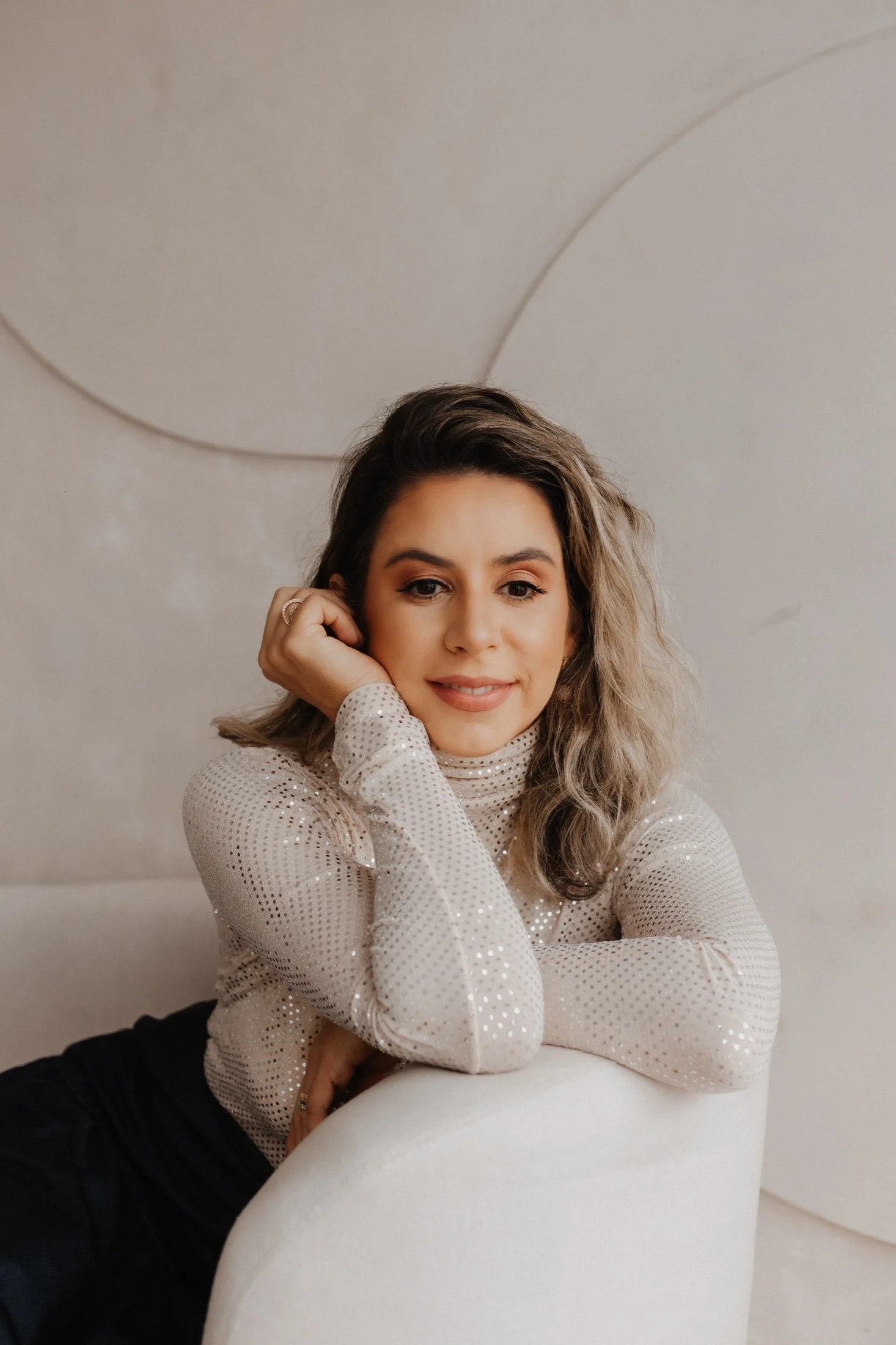 Dra. Valéria Franzon, sorrindo, com a mão no rosto